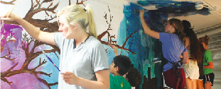 Student volunteers work tirelessly to complete the mural. 