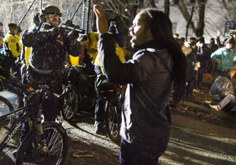 Jeremiah Ellison, Blake alumn, peacefully protests as police officers aim a gun at him. He was not shot during these demonstrations. 