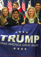 Students stand behind a Trump banner at a rally in Iowa. 