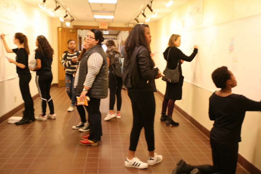 Members of the community add their contribution to the Today I Am... wall which included the name of everyone (students, faculty, and employees) and an equal space for them to create on the day of the inauguration. 