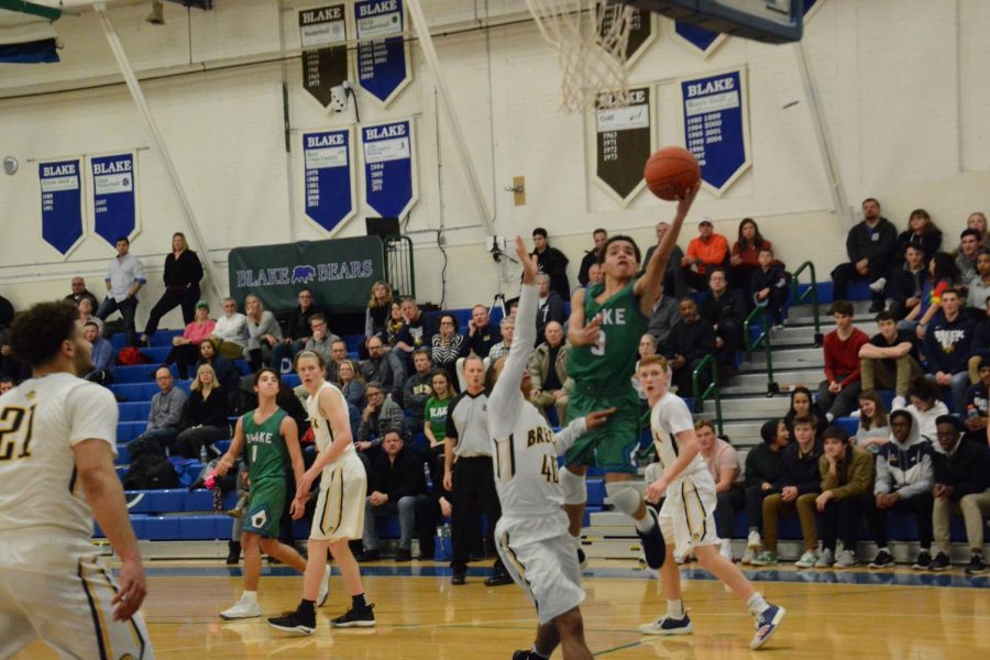 Robert Grace III drives the lane in a game against rival Breck on February 8