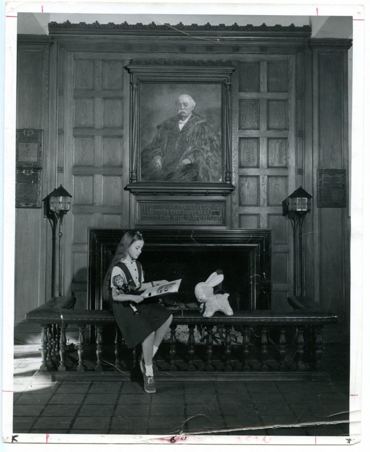 A student studies in front of the main fireplace of Northrop, circa 1951