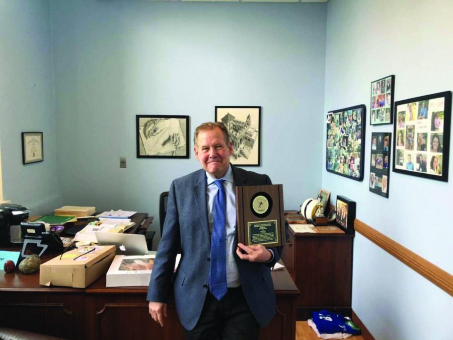 Menge poses with his award in his office. He has always made it a point
of pride for his teams to display sportsmanship.