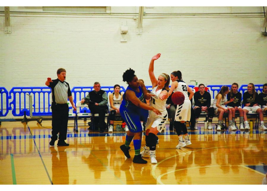 Cheryl Minde 20, the only senior on the team this year, reaches around a defender to pass the ball to her teammate.