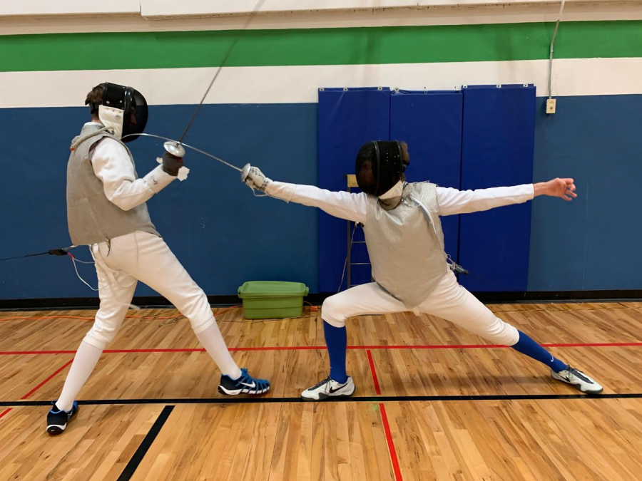 Fencers Ryan Thrasher 23 (left) and Theo Fechtmeyer 23 (right) are in the middle of a match at practice.