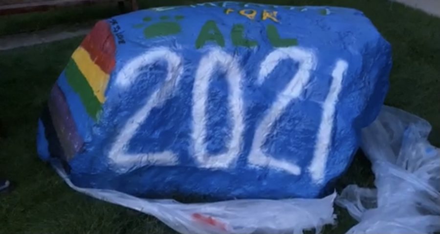 Seniors paint the rock outside the West Entrance. 