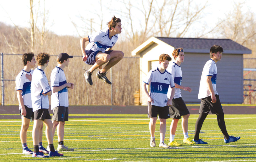Graham Heathcote 22 jumping in the air, warming up for game vs. Wayzata. Boys varsity team won against Wayzata. This was a monumental win for boys varsity Ultimate team. 