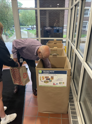 Jim Arnold and Sally Countryman ‘23 place ketchup, oatmeal and other goods into the Legacy Day donation bins. 