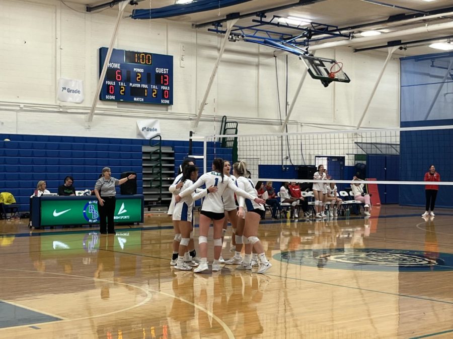 The girls’ volleyball team huddles up, discussing their gameplan with one another before they carry on with the game.