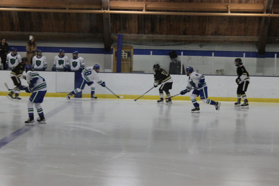 Forward Samantha Negaard ‘23 dumps the puck into the zone while Abraham and Malika Chebaclo ‘25 tag up.