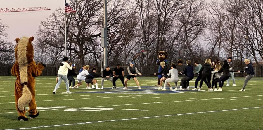 Students take on the Mustangs in a tug of war while both mascots cheer them on.