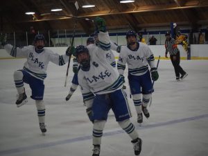 Landon Bell ‘26, Captain Oliver Duininck ‘24, and Joe Erickson ‘26 celebrate for
the camera with teammates during the Jan. 16 game against Breck at Blake Ice Arena.