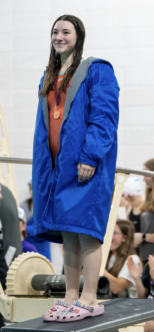 Besikof stands with her 100-meter Butterfly sixth-place medal during the 2025 Sections meet. 26 girls swam in the event.